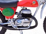 a red and green dirt bike parked on the side of the road