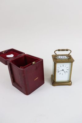two miniature clocks sitting next to each other on a table