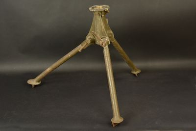 une table trépied ancienne en laiton avec un plateau en verre, sur fond noir
