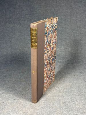 an old book sitting on top of a table next to a gray wall