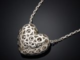 a close up of a heart shaped pendant on a chain