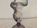 a glass sculpture of a woman holding a glass vase