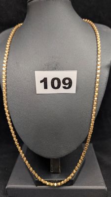 un gros plan d'un collier sur un mannequin, avec une étiquette de prix