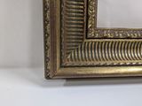 an image of a gold framed mirror on a white wall