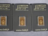 three gold bars are sitting next to each other on a table