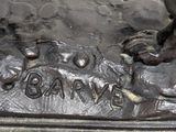 a bronze statue of a dog and a cat on a rock