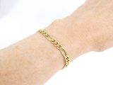 someone is wearing a gold bracelet with a chain on their arm