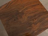 a wooden table with a square top on the floor