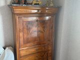 une commode surmontée d'une horloge, placée dans un coin de la pièce