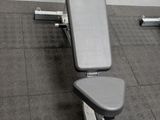 a gym with a bench and weights in the middle of the room