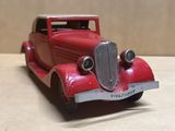 une maquette rouge d'une voiture posée sur une table