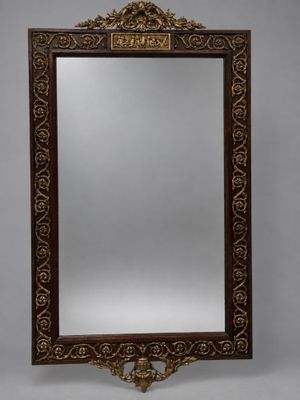 an ornately carved mirror with a wooden frame and gold decoration