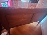 a wooden table with a marble top in a room
