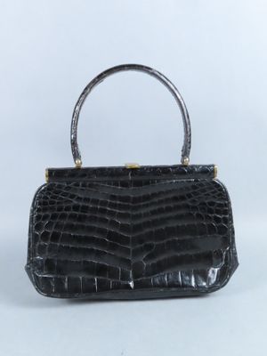 un sac à main en cuir de crocodile noir muni d'une poignée en métal