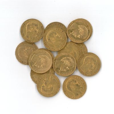 quelques pièces d'or sont empilées sur une surface blanche