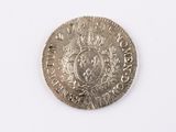 an old silver coin with a crown on it on a white surface