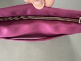 someone is holding a purple purse with a zipper in it