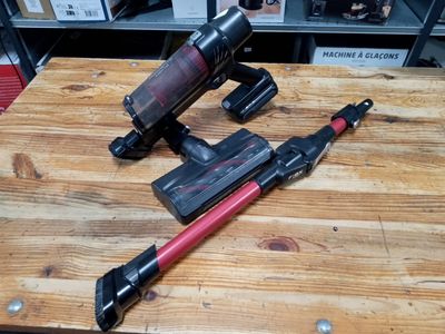 two vacuums that are on a wooden table