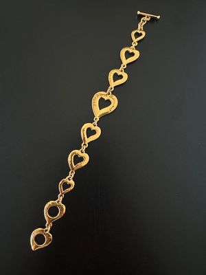un gros plan sur un bracelet en or orné de cœurs