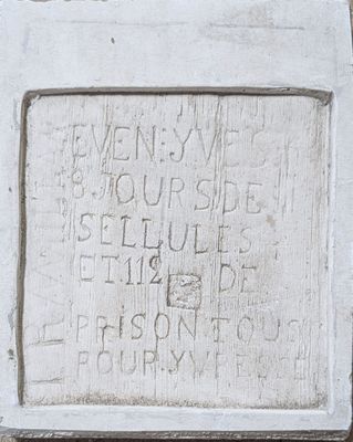 a plaque on the side of a building with writing on it