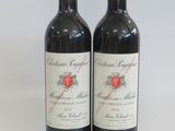 two bottles of red wine sitting next to each other on a table