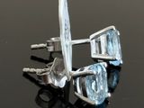 pair of blue topaz and white topaz earrings on a black surface