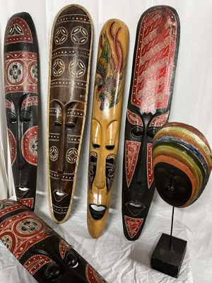 cinq masques en bois exposés sur un fond blanc