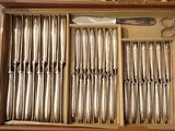a lot of silverware in a box with a pair of scissors in it