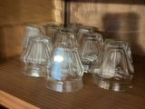 a lot of glasses sitting on a shelf in a room