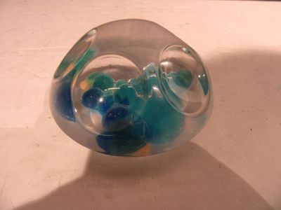 un objet en verre contenant des billes bleues et vertes