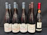 six bouteilles de vin sont alignées sur une table