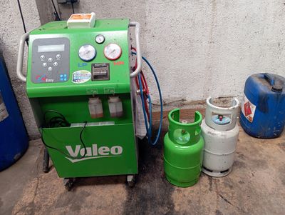 une machine verte posée à côté de deux bouteilles de gaz propane