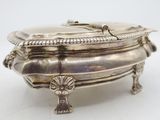 an antique silver plate with a lid on a white surface