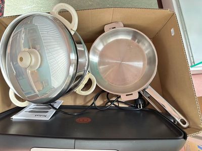 deux casseroles et poêles dans une boîte posée sur une table