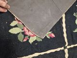 someone is cutting a piece of fabric with a knife on a rug