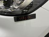 a close up of a car ' s headlight with a sticker on it