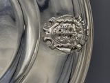 a silver plate with a crest on it on a table