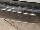 the rear bumper of a silver car with scratches on it