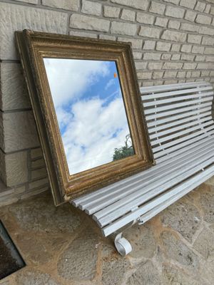 un banc sur lequel est posé un miroir, à côté d'un mur de briques
