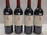 three bottles of red wine are lined up on a table