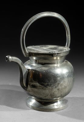 an antique silver teapot with a handle on a white surface