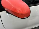 a red mirror on the side of a white car