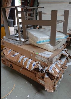 un chariot sur lequel est posé un matelas, dans un entrepôt