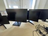 three computer monitors sitting on top of a table next to a laptop