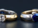 deux bagues en or et en argent, ornées de saphirs bleus, sur un fond noir