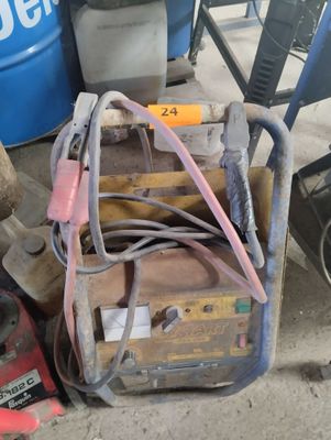 a pile of tools sitting on the ground next to a barrel
