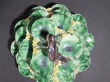 a green and yellow flower brooch on a black surface