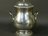 an antique silverplated teapot with a lid on a black surface