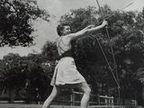 a black and white photo of a woman holding a bow and arrow