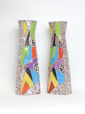 two colorful vases sitting on a white surface